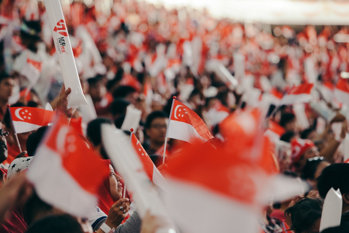 expat life in singapore - many waving singapore flags